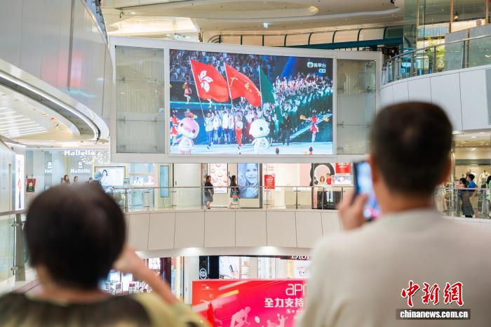 11月9日晚,香港市民在觀塘的一家商場內通過大屏幕觀看在廣州舉行的第十五屆全國運動會開幕式。圖為大屏幕顯示出粵港澳三地運動員代表團一同入場。 中新社記者 侯宇 攝 11月9日晚,香港市民在觀塘的一家商場內通過大屏幕觀看在廣州舉行的第十五屆全國運動會開幕式。圖為大屏幕顯示出粵港澳三地運動員代表團一同入場。 中新社記者 侯宇 攝