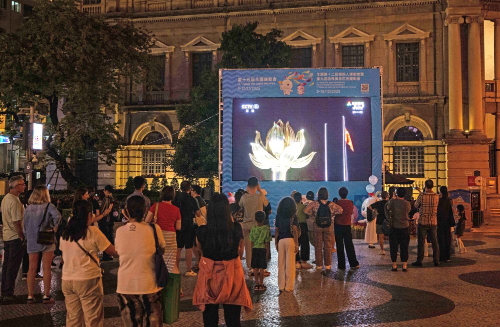 11月9日，第十五屆全國運動會開幕式在廣東奧林匹克體育中心舉行，這是群眾在澳門街頭觀看直播。新華社發(fā)（張金加 攝）